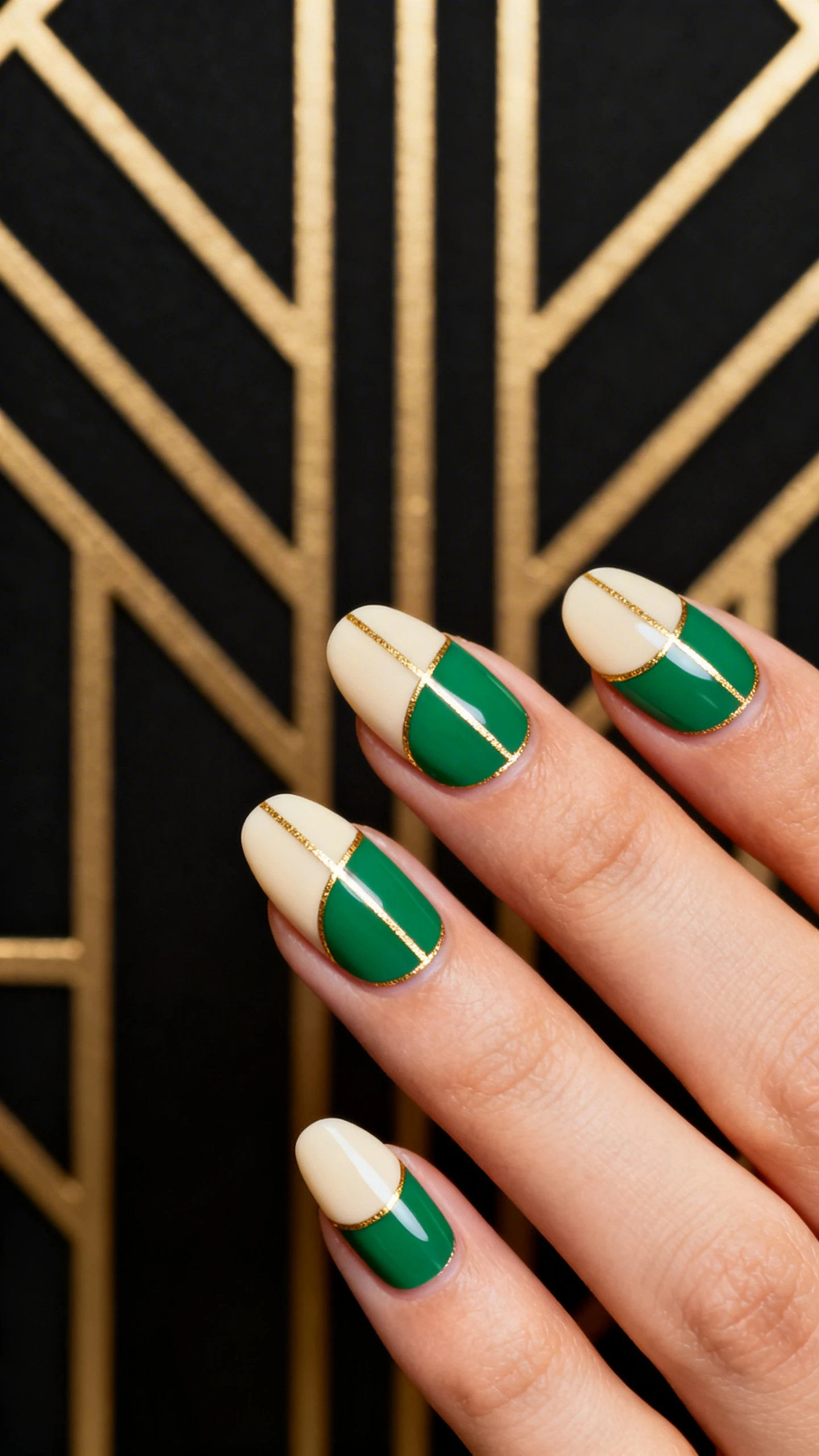 A macro, high-resolution photo of one hand with short-to-medium almond nails in an Art Deco half-moon design: sheer cream base with clean, 3–4 mm semicircular half-moons left bare at the cuticle; the rest of each nail filled with opaque emerald panels, outlined by ultra-fine metallic gold striping for geometric elegance; glossy top coat; styled against an Art Deco-inspired backdrop with angular gold lines on matte black, soft directional lighting, nails in crisp focus, no faces visible.