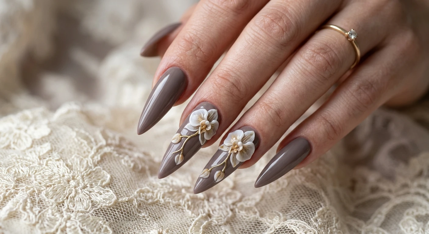A beautiful macro photograph of one hand showing a detailed nail design, featuring dramatic, sharp stiletto nails painted in a rich, cool-toned taupe. A masterpiece artwork spans across the middle and ring fingers, showcasing a large, asymmetrical 3D orchid branch with sweeping petals crafted from a realistic mix of translucent white and pale tan acrylic. High-resolution, sharp focus on the nails, set against an aesthetic vintage background of antique lace and soft shadows. Modern, Instagram-worthy photography style, no faces visible, focus ONLY on the nails and hand., macro nail photography, high quality, Instagram-worthy, clean composition