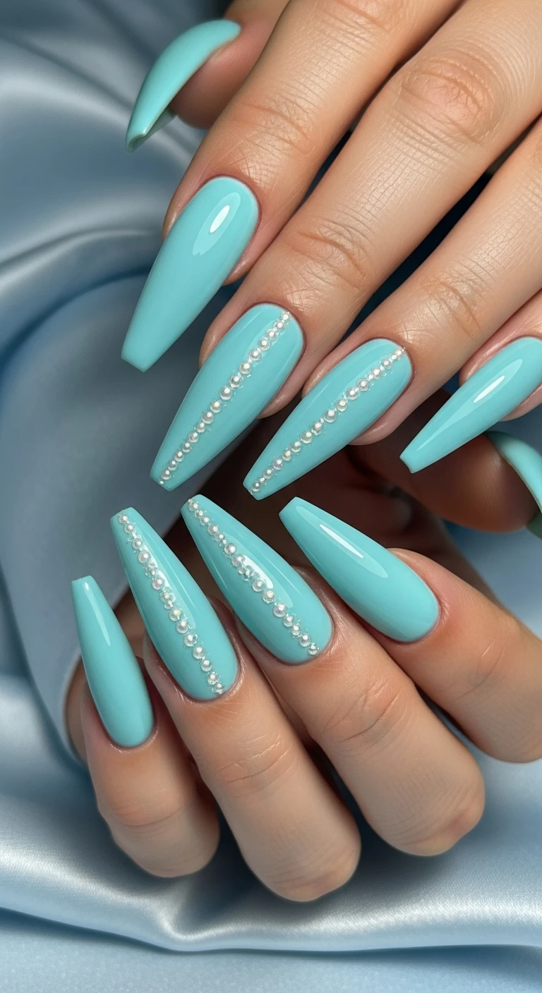 A beautiful macro photograph of one hand showing a nail design in detail, featuring dramatic, long stiletto nails. The nails are painted with a solid, opaque pastel robin's egg blue base coat, decorated with tiny, iridescent white micro-pearls applied in a minimalist vertical line down the exact center of each nail, and finished with a high-shine gloss. The hand is displayed against an aesthetic background of smooth, pale blue satin with soft, glowing lighting. High-resolution, sharp focus on the nails, modern, Instagram-worthy photography style. No faces visible, focus ONLY on the nails and hand., macro nail photography, high quality, Instagram-worthy, clean composition
